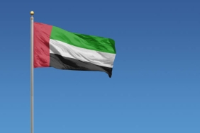 Flag of United Arab Emirates in front of a clear blue sky