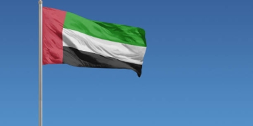 Flag of United Arab Emirates in front of a clear blue sky