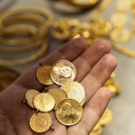 Human hand holding Turkish Gold coin in hand