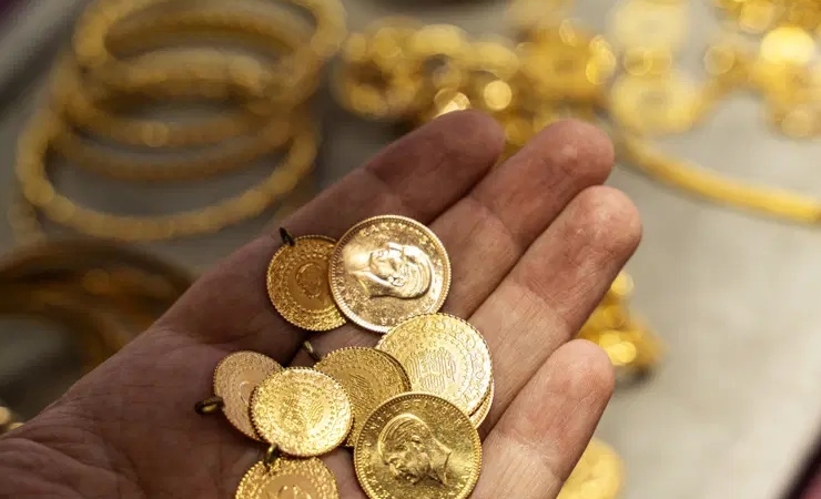 Human hand holding Turkish Gold coin in hand